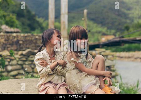 Deux jeunes filles passent du temps ensemble à l'extérieur ; Ngoc chien, Muong la District, son la, Vietnam Banque D'Images