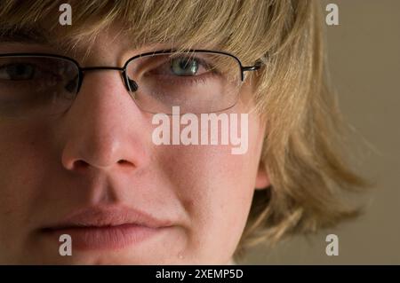 Portrait en gros plan d'un adolescent avec des cheveux blonds et des lunettes ; Studio Banque D'Images