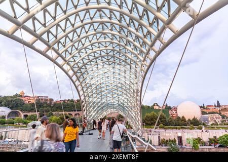 Tbilissi, Géorgie - 16 juin 2024 : le pont de la paix est un pont piétonnier en forme d'arc, une construction en acier et en verre au-dessus de la rivière Kura, reliant t Banque D'Images