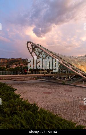 Tbilissi, Géorgie - 16 juin 2024 : le pont de la paix est un pont piétonnier en forme d'arc, une construction en acier et en verre au-dessus de la rivière Kura, reliant t Banque D'Images