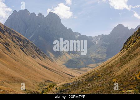 Beau paysage montagneux du parc national de Kazbegi, avec des sommets escarpés sur une crête et des pentes verdoyantes dans une vallée ; Géorgie Banque D'Images