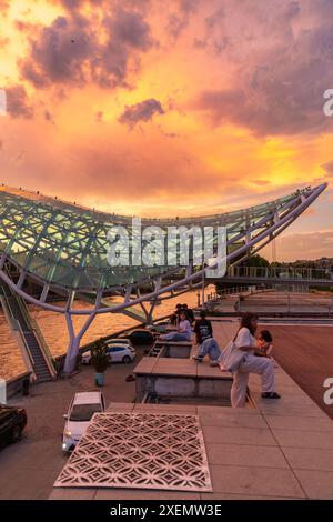 Tbilissi, Géorgie - 16 juin 2024 : le pont de la paix est un pont piétonnier en forme d'arc, une construction en acier et en verre au-dessus de la rivière Kura, reliant t Banque D'Images