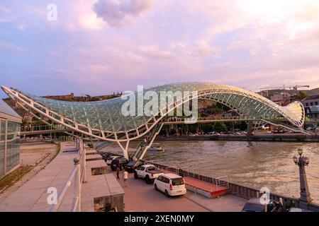 Tbilissi, Géorgie - 16 juin 2024 : le pont de la paix est un pont piétonnier en forme d'arc, une construction en acier et en verre au-dessus de la rivière Kura, reliant t Banque D'Images