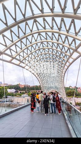 Tbilissi, Géorgie - 16 juin 2024 : le pont de la paix est un pont piétonnier en forme d'arc, une construction en acier et en verre au-dessus de la rivière Kura, reliant t Banque D'Images