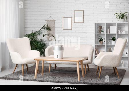 Humidificateur moderne sur la table basse près du canapé blanc dans le salon élégant Banque D'Images