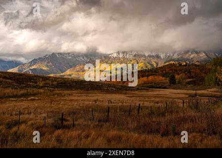 vue panoramique des couleurs de l'automne sur les pentes des sommets enneigés couverts de nuages gris orageux près de Grand Junction Banque D'Images