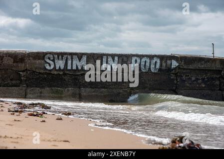 Margate, Royaume-Uni. 28 juin 2024. Sur le côté du Margate Lido, le graffiti dit "piscine", mais les lettres surlignées disent seulement "NAGER DANS LE POO" en raison de la forte pollution des eaux usées dans les eaux britanniques. Le graffiti fait référence à la pollution des eaux usées causée par le scandale Southern Water. Selon l'Agence environnementale, Southern Water a rejeté les eaux usées brutes dans la mer un choc de plus de 317000 heures l'année dernière. (Photo de Krisztian Elek/SOPA images/SIPA USA) crédit : SIPA USA/Alamy Live News Banque D'Images