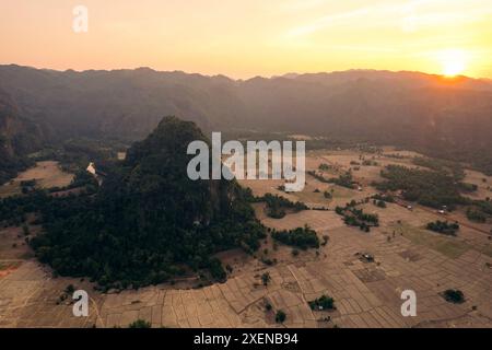 Lumière dorée du coucher de soleil sur des terres agricoles dans une vallée entourée de karst calcaire près de Kong Lor Cave au Laos ; province de Khammouane, Laos Banque D'Images