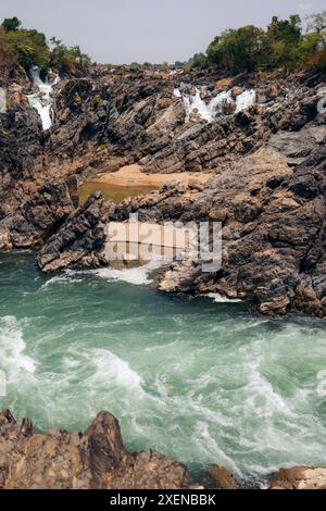 Chutes d'eau Li Phi Somphamit avec des cascades sur une falaise rocheuse avec des rives sablonneuses et courant fluvial au Laos ; Khon Tai, Laos Banque D'Images