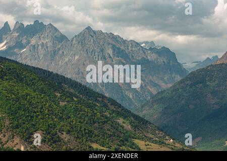 Flancs de montagnes boisées et sommets escarpés des montagnes du Caucase avec des nuages sombres au-dessus ; Hebudi, Svanteti, Géorgie Banque D'Images