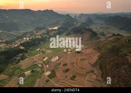 Terres agricoles en terrasses sur une colline avec une vallée luxuriante dans les montagnes au crépuscule, Ha Giang, Vietnam ; Quan Ba, Ha Giang, Vietnam Banque D'Images