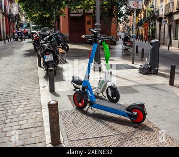 06.19.2024, Madrid, Espagne : scooters de mobilité électrique de location Dott et Lime garés dans une rue du centre-ville Banque D'Images