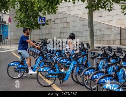 06.19.2024, Madrid, Espagne : jeune couple louant des vélos électriques de location BiciMAD à partir d'une station d'accueil dans la rue Banque D'Images