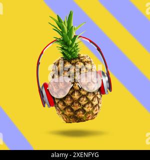 Ambiance estivale. Ananas avec lunettes de soleil et écouteurs sur fond de couleur. Circulaire de fête ou autre article saisonnier Banque D'Images