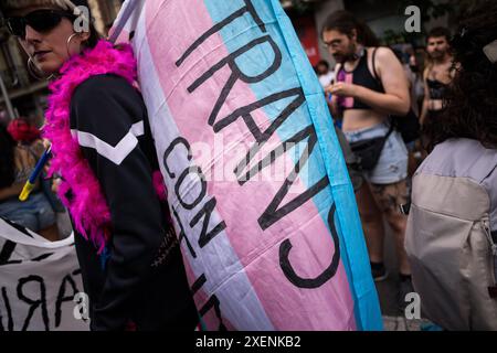 Madrid, Espagne. 28 juin 2024. Une fille trans tient un drapeau TRANS, lors de la manifestation Critical Pride qui a visité les rues de Madrid, cette année, c'était pour soutenir le peuple palestinien. Différents groupes qui composent la plateforme de la fierté critique de Madrid ont organisé une manifestation alternative contre les événements officiels de la World Pride et ont cherché à faire valoir les droits du collectif LGTBIQ. Crédit : SOPA images Limited/Alamy Live News Banque D'Images