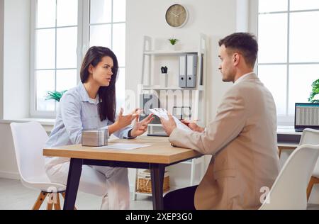 Jeune femme réfléchie et travailleur d'affaires masculin travaillant au bureau, parlant sur l'entretien d'entreprise Banque D'Images