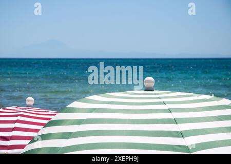 Parasols de plage rayés sur la plage de sable près de la mer gros plan sur la plage de sable près de la mer Banque D'Images