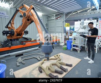 Urumqi, région autonome ouïgur du Xinjiang. 28 juin 2024. Un employé d'une société d'instruments de précision basée à Nanjing présente la technologie d'impression 3D à la 8ème exposition Chine-Eurasie à Urumqi, dans la région autonome ouïgur du Xinjiang, au nord-ouest de la Chine, le 28 juin 2024. La 8ème exposition Chine-Eurasie, qui s'est tenue au Centre international de congrès et d'exposition du Xinjiang au pied des montagnes de Tianshan, a présenté les machines lourdes développées en Chine, la construction intelligente et les technologies de production. Crédit : Li Renzi/Xinhua/Alamy Live News Banque D'Images