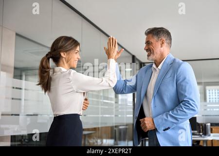 Deux heureux cadres professionnels de l'équipe d'affaires donnant haut cinq dans le bureau. Banque D'Images