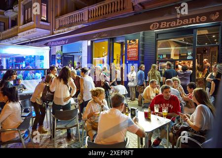 Les gens buvant du vin et mangeant des tapas dans un bar, 'pintxo pote', quartier gros, Donostia (Saint-Sébastien), Gipuzkoa, pays basque, Espagne Banque D'Images