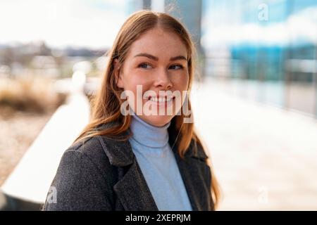 Portrait d'une belle étudiante assise sur un banc dans la ville avec un cahier faisant des plans d'étude Banque D'Images