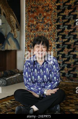 (240629) -- PÉKIN, 29 juin 2024 (Xinhua) -- Wang Guoying est assis sur un tapis de palais dans le studio de Ji Yu à Pékin, capitale de la Chine, le 27 juin 2024. Le tapis du palais de Pékin est un magnifique exemple des techniques traditionnelles de tissage de tapis de Chine. Connu pour ses processus de production complexes et ses beaux motifs, le tapis du palais représente le summum de l'art du tissage chinois. La production comprend quatre étapes principales : teinture avec des herbes traditionnelles chinoises, création de patrons, tissage et façonnage, et enfin, finitions. Comme l'un des huit artisanats impériaux de Pékin, l'art de PA Banque D'Images