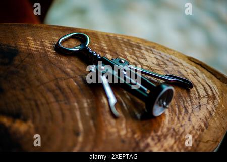 Présentant un tire-bouchon classique posé sur une table en bois, incarnant la simplicité et l'élégance dans la culture du vin. Banque D'Images
