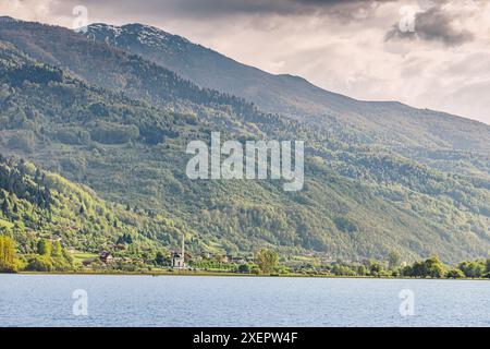 À Plav, au Monténégro, une mosquée surplombe le lac tranquille, se fondant dans le paysage pittoresque des Balkans et son architecture traditionnelle. Banque D'Images