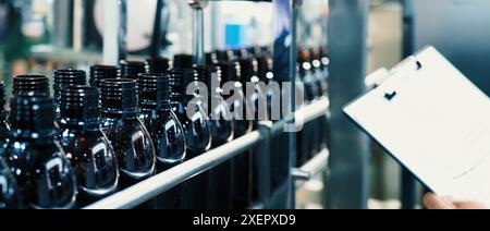 Machine d'automatisation de remplissage de bouteilles dans l'usine moderne. Démonstration technologique de bouteilles de remplissage et de bouchage dans l'industrie. Inspection des flacons pour Banque D'Images