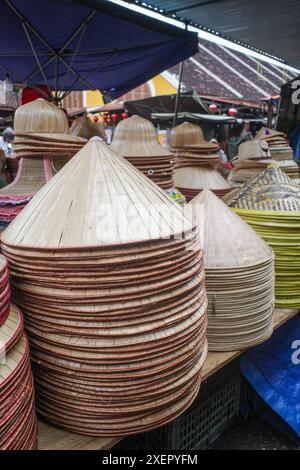 Hoi an, Vietnam - 8 Feb, 2024 : piles de chapeaux coniques asiatiques traditionnels à vendre au marché central de Cho Hoi an, Vietnam Banque D'Images