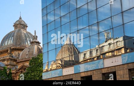 Dôme du palais CEC reflétant la façade vitrée de l'hôtel Novotel à Bucarest, Roumanie Banque D'Images