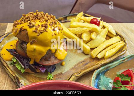 La combinaison de viande juteuse, fromage fondu, légumes frais et petits pains mous, avec croustillant, savoureuses frites, est irrésistible Banque D'Images