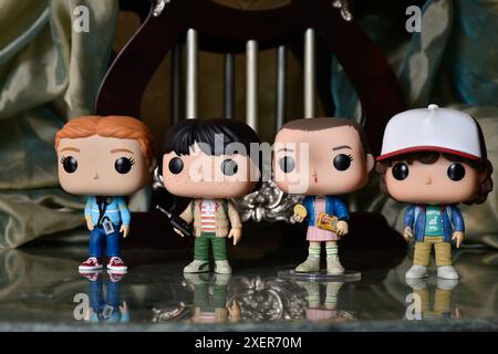 Funko Pop figurines de Mike, Eleven, Dustin et Max de la série télévisée populaire Stranger Things. Plancher de réflexion, rideau, palais vintage, colonnes. Banque D'Images