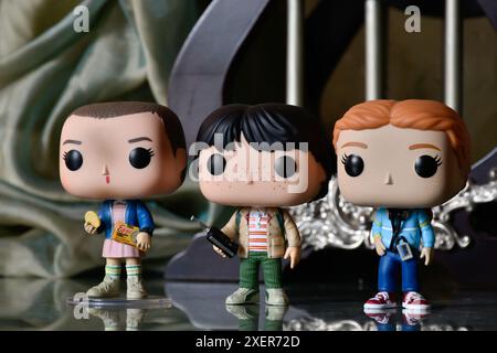 Funko Pop figurines d'action de Eleven, Mike et Max de la série télévisée d'horreur populaire Stranger Things. Plancher de réflexion, rideau, palais vintage, colonnes. Banque D'Images