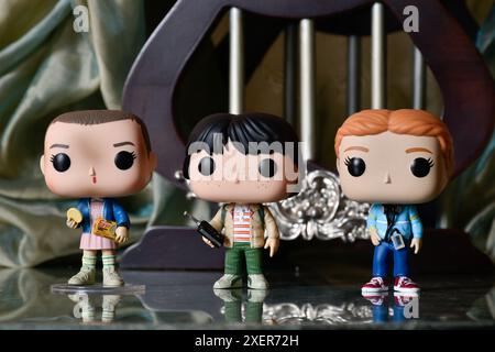 Funko Pop figurines d'action de Eleven, Mike et Max de la série télévisée d'horreur populaire Stranger Things. Plancher de réflexion, rideau, palais vintage, colonnes. Banque D'Images