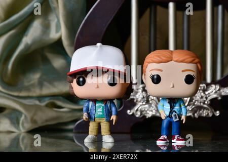 Funko Pop figurines de Dustin et Max de la série télévisée d'horreur populaire Stranger Things. Plancher de réflexion, rideau vert, palais vintage, colonnes. Banque D'Images