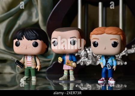 Funko Pop figurines d'action de Eleven, Mike et Max de la série télévisée d'horreur populaire Stranger Things. Plancher de réflexion, rideau, palais vintage, colonnes. Banque D'Images