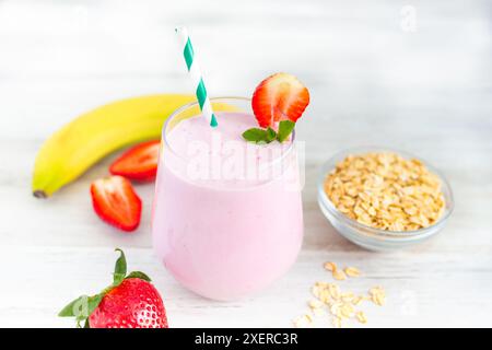 Smoothie Milk-Shake aux fraises avec banane et flocons d'avoine. Petit déjeuner sain. Menu diététique et sain. Un coup de fouet d'énergie et de vitamines. Banque D'Images
