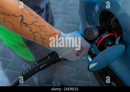 Hand Man Refill and filling Oil Gas Fuel at station. Gun petrol in the tank to fill. Pumping gasoline fuel in car at gas station. Refueling automobile Banque D'Images