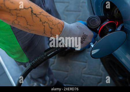 Hand Man Refill and filling Oil Gas Fuel at station. Gun petrol in the tank to fill. Pumping gasoline fuel in car at gas station. Refueling automobile Banque D'Images