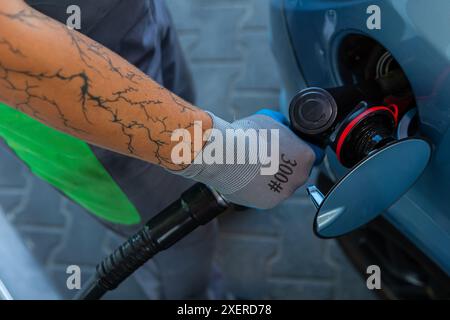 Hand Man Refill and filling Oil Gas Fuel at station. Gun petrol in the tank to fill. Pumping gasoline fuel in car at gas station. Refueling automobile Banque D'Images