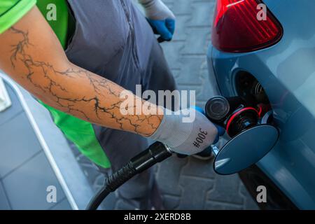 Hand Man Refill and filling Oil Gas Fuel at station. Gun petrol in the tank to fill. Pumping gasoline fuel in car at gas station. Refueling automobile Banque D'Images