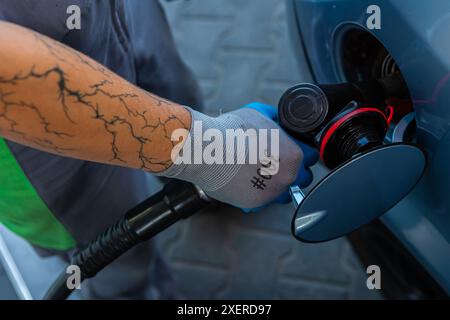 Hand Man Refill and filling Oil Gas Fuel at station. Gun petrol in the tank to fill. Pumping gasoline fuel in car at gas station. Refueling automobile Banque D'Images