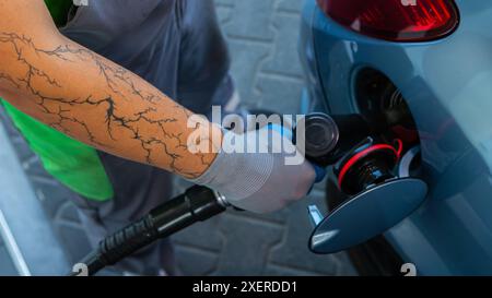 Hand Man Refill and filling Oil Gas Fuel at station. Gun petrol in the tank to fill. Pumping gasoline fuel in car at gas station. Refueling automobile Banque D'Images