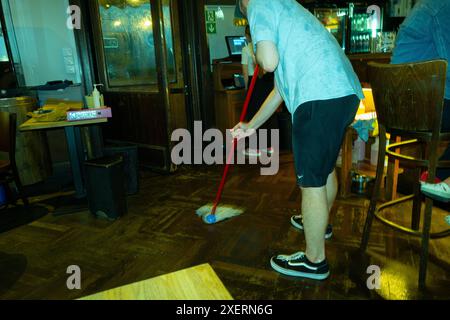 Varsovie, Pologne. 28 juin 2024. Un homme est vu balayer un sol dans un restaurant après une averse à Varsovie, Pologne, le 28 juin 2024. (Photo de Jaap Arriens/Sipa USA) crédit : Sipa USA/Alamy Live News Banque D'Images