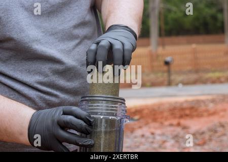 Un employé du système de traitement de l'eau domestique remplace le filtre sur l'eau de ligne résidentielle Banque D'Images