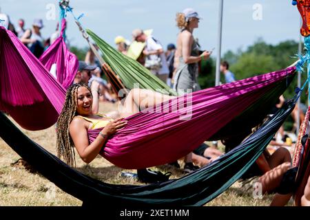 Glastonbury, Royaume-Uni. Jour 4, 29 juin 2024. Un festivalier se détend dans un hamac dans l'arène Park Stage au Glastonbury Festival, Worthy Farm dans le Somerset. Date de la photo : samedi 29 juin 2024. Le crédit photo devrait se lire : David Jensen / Alamy Live News Banque D'Images