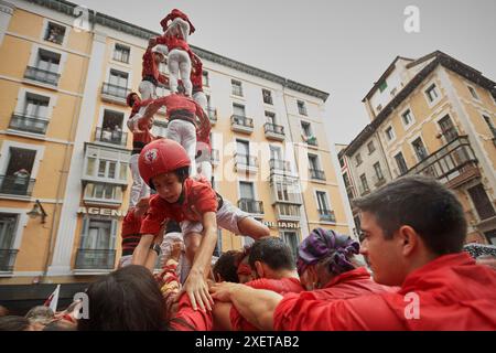 Pampelune, Espagne. 29 juin 2024. Arnau, âgé de seulement 5 ans, descend du château que les castellers ont construit lors de l'exposition. Les membres de la Colla Vella dels xiquets de Valls ont organisé une exposition de leurs tours humaines à Pampelune, Navarre, Espagne. Crédit : SOPA images Limited/Alamy Live News Banque D'Images