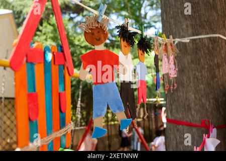 Poupées de bâton de popsicle faites à la main avec des caractéristiques uniques et des vêtements suspendus sur une corde avec des chevilles à l'extérieur. Les poupées représentent différentes ethnies et sont décorées avec des textiles colorés. Banque D'Images