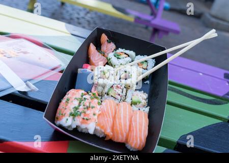 Une paire de baguettes placées sur une assiette de sushis de fruits de mer fraîchement préparés dans un stand de Street food London Covent Garden UK Banque D'Images